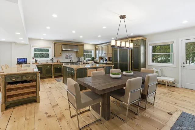a kitchen with stainless steel appliances granite countertop a table chairs sink and cabinets