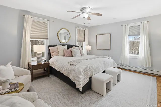 a bedroom with two beds and large windows