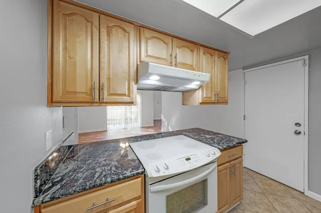 a bathroom with a granite countertop toilet sink and mirror