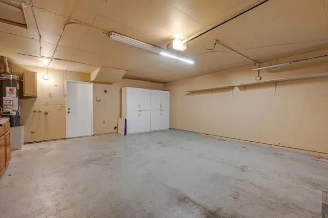 a view of a backyard with large trees and wooden fence