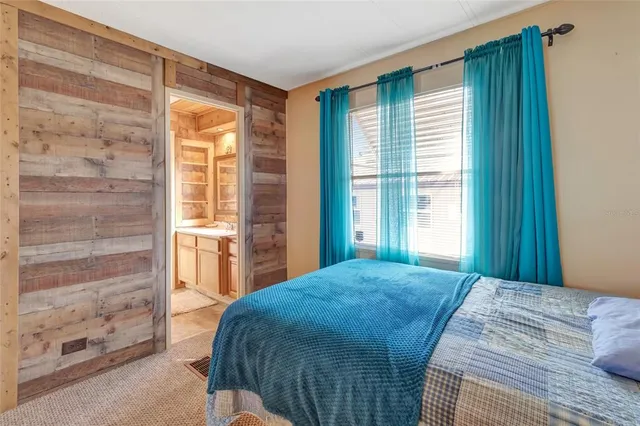 a bedroom with a bed and a large window