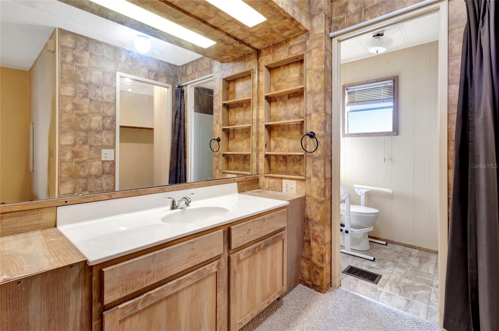 1409 Ridge Road Tavares, FL 32778 - Photo 26 of 36 a bathroom with a sink and a mirror