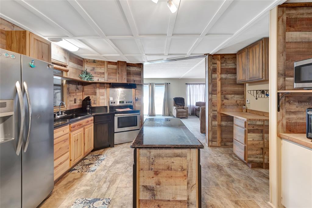 1409 Ridge Road Tavares, FL 32778 - Photo 8 of 36 a kitchen with stainless steel appliances granite countertop a refrigerator a stove and a sink