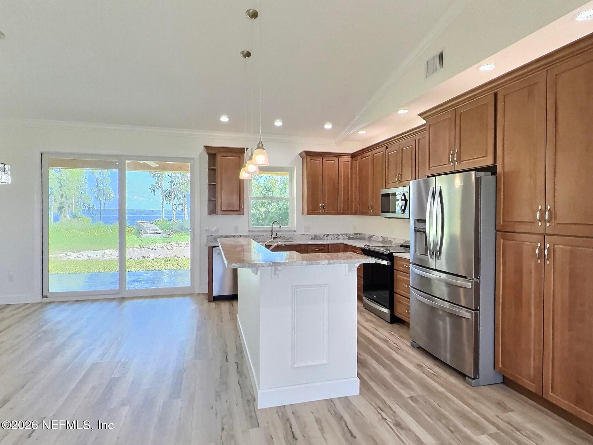 159 Mays Cove Road East Palatka, FL 32131 - Photo 12 of 62 a kitchen with kitchen island wooden floors appliances and cabinets