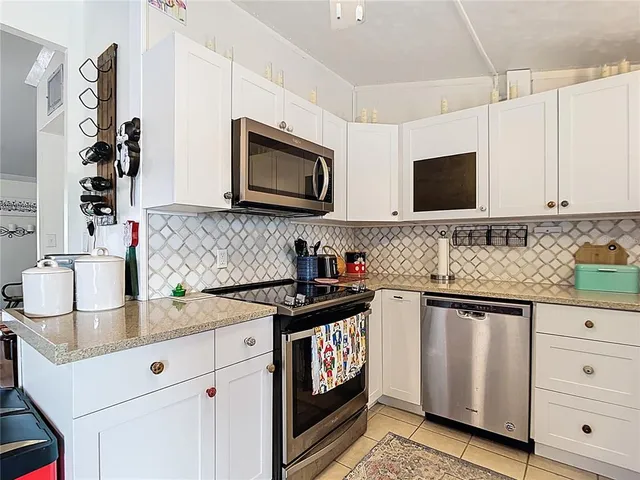 a kitchen with granite countertop a sink stove and microwave