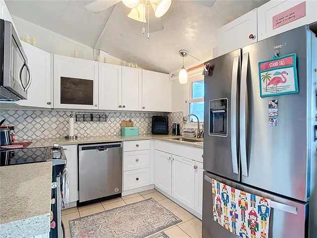 a kitchen with stainless steel appliances granite countertop a refrigerator and a stove top oven