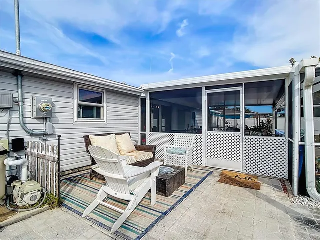 a view of a patio with a table and chairs and floor to ceiling window