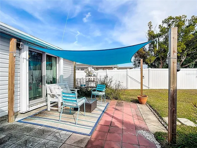 a view of a patio with table and chairs potted plants with floor to ceiling window