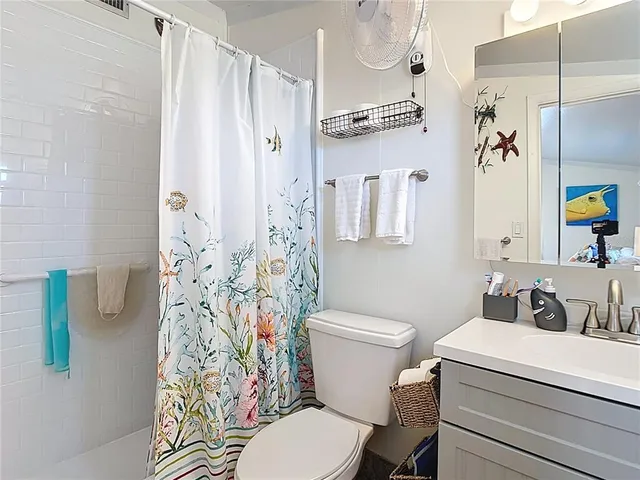 a white toilet sitting next to a bathroom sink