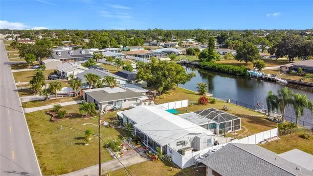 an aerial view of a house with swimming pool and lake view