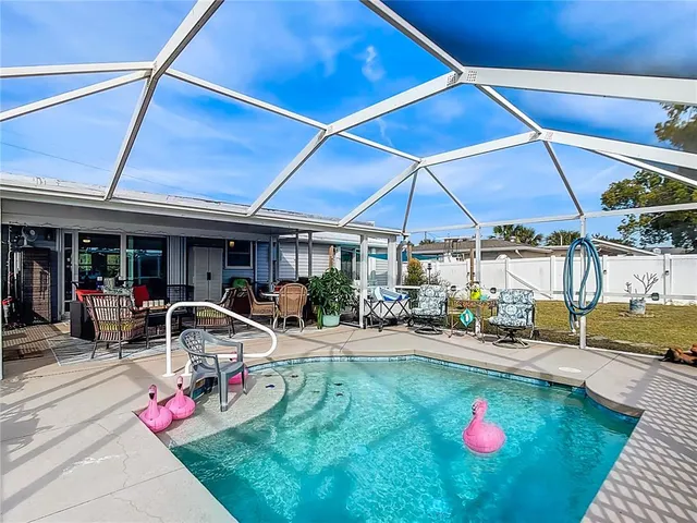 a view of a backyard with table and chairs under an umbrella