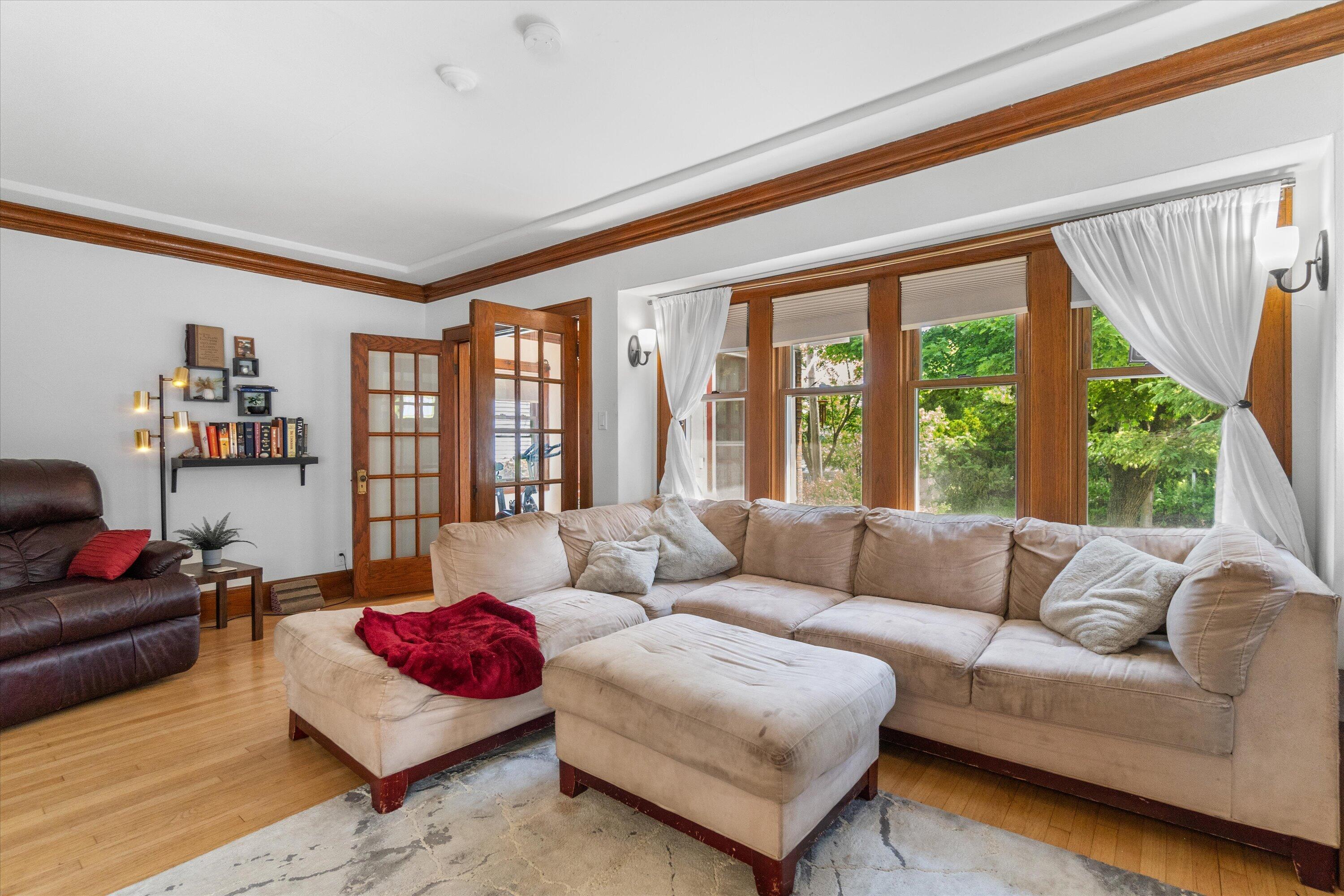 159 North 59th Street Milwaukee, WI 53213 - Photo 31 of 34 Spacious living room featuring original woodwork, built-in shelving, and an abundance of natural light from large windows.