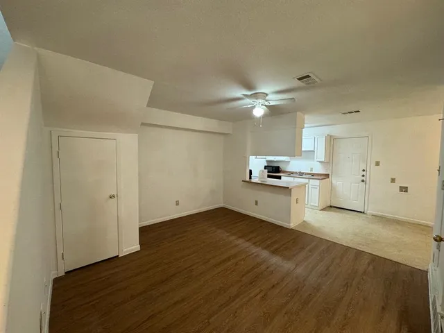 a view of kitchen with granite countertop cabinets and refrigerator