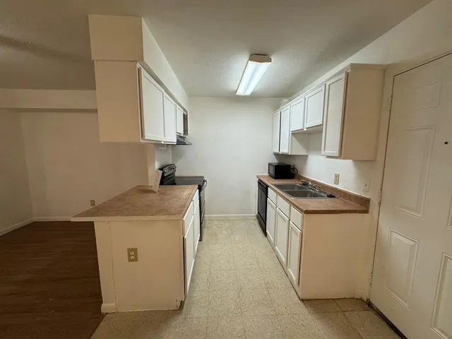 a kitchen with a stove top oven and cabinets