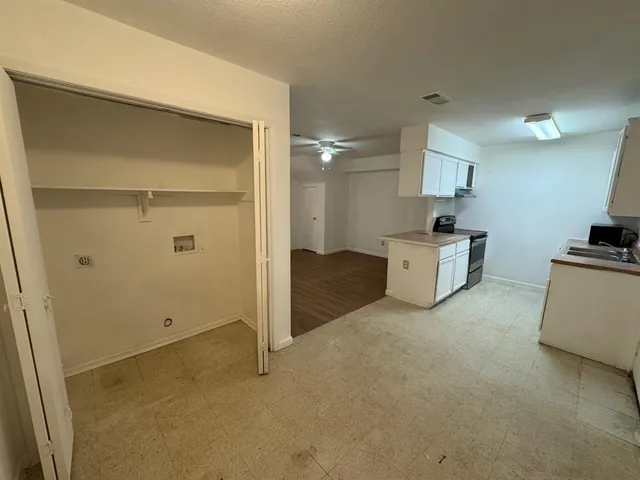 a view of an empty room with closet and a window