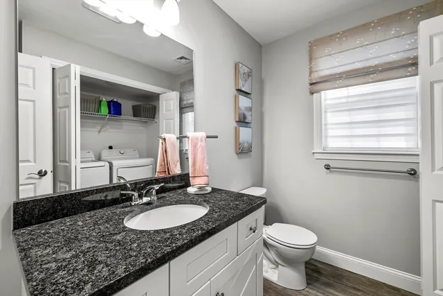 a bathroom with a granite countertop sink and a mirror