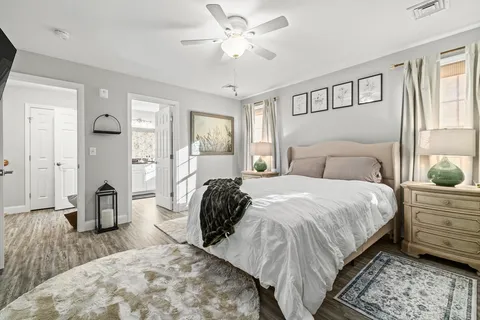 a bedroom with a bed a large window and potted plant