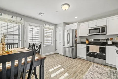 a kitchen with a table chairs refrigerator and microwave