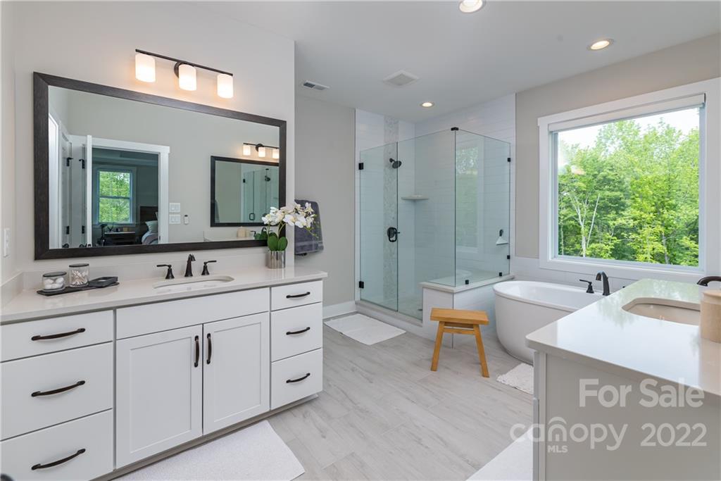 513 Small Batch Path Fort Mill, SC 29708 - Photo 24 of 48 a spacious bathroom with a double vanity sink a large mirror and a bathtub