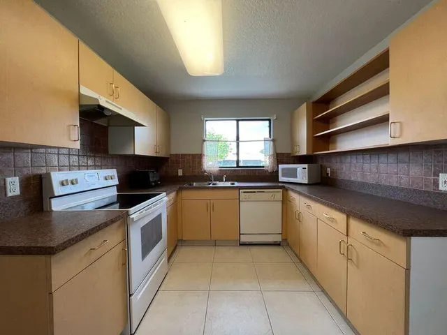a kitchen with stainless steel appliances granite countertop a sink and white cabinets
