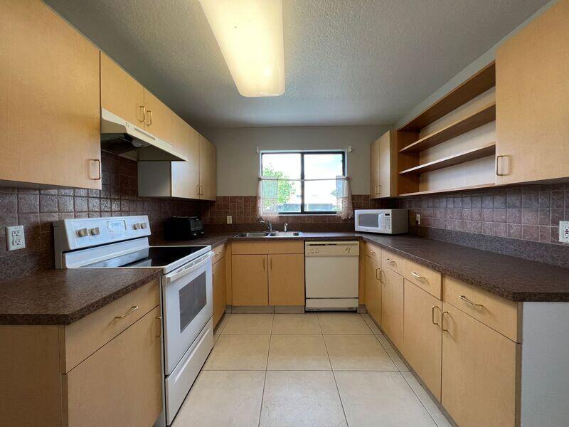 10225 Northwest 33rd Street Sunrise, FL 33351 - Photo 17 of 51 a kitchen with stainless steel appliances granite countertop a sink and white cabinets