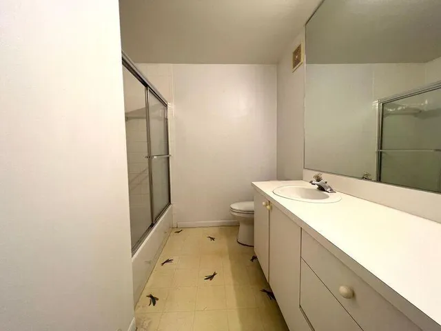 a bathroom with a sink and mirror with toilet