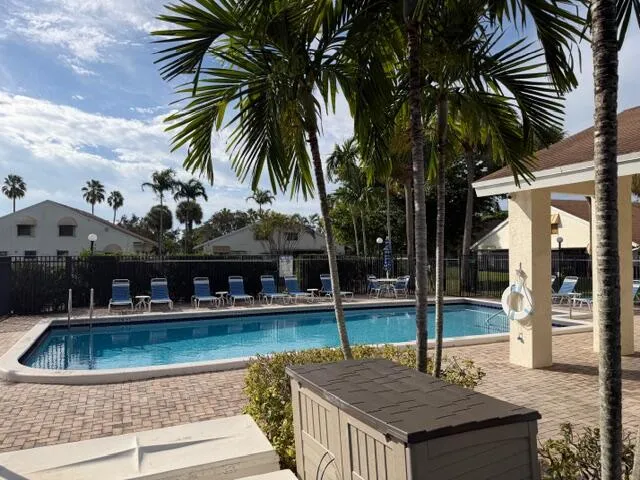 a view of a house with pool and chairs