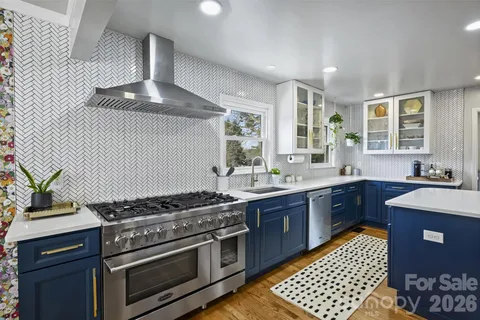 a kitchen with stainless steel appliances a stove a sink and a refrigerator