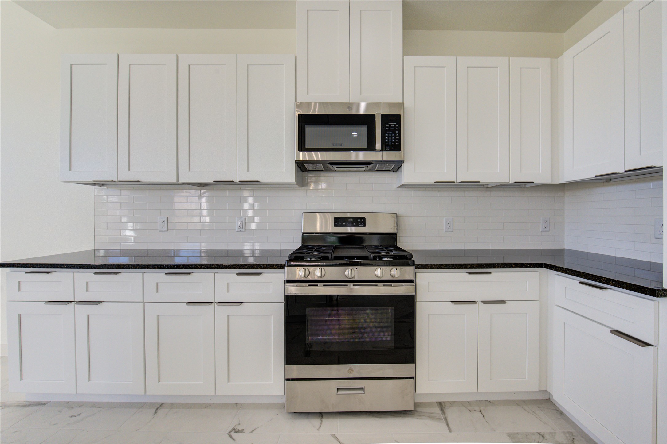 2931 El Fenice Lane Houston, TX 77057 - Photo 11 of 46 a kitchen with white cabinets and stainless steel appliances