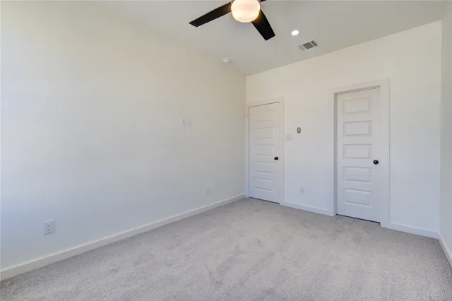 an empty room with windows and closet