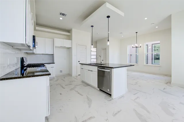 a kitchen with stainless steel appliances granite countertop a sink and a refrigerator