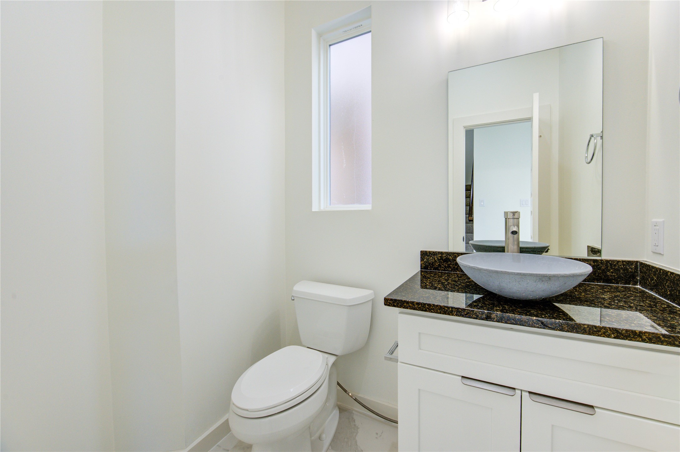 2931 El Fenice Lane Houston, TX 77057 - Photo 34 of 46 a bathroom with a granite countertop toilet a sink and mirror