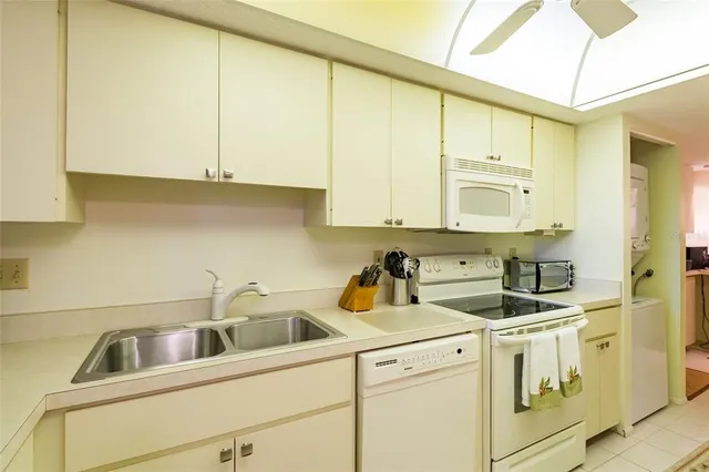 a kitchen with white cabinets and white appliances