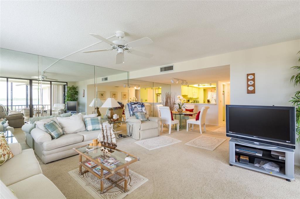 8767 Midnight Pass Road, Unit 506F Sarasota, FL 34242 - Photo 17 of 37 a living room with furniture and a flat screen tv