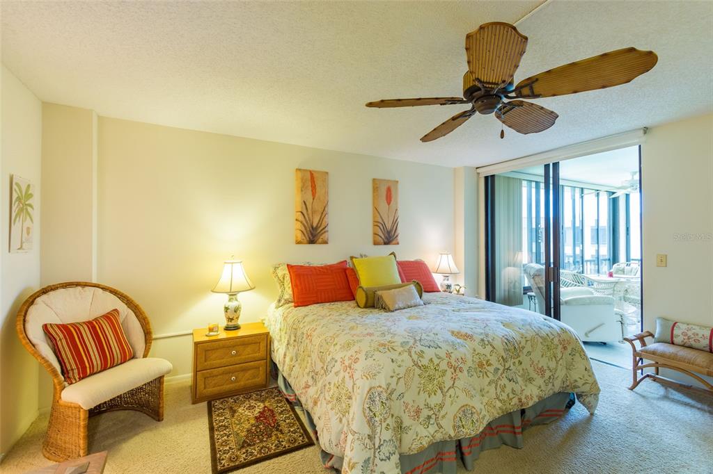 8767 Midnight Pass Road, Unit 506F Sarasota, FL 34242 - Photo 21 of 37 a bed room with a bed and a chair