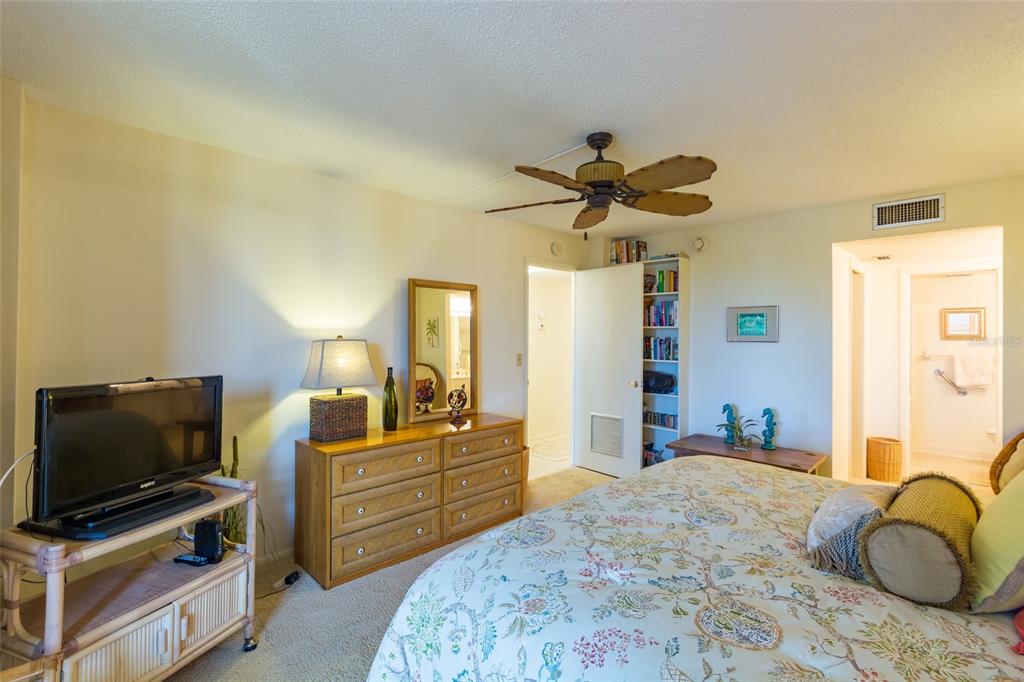 8767 Midnight Pass Road, Unit 506F Sarasota, FL 34242 - Photo 22 of 37 a bedroom with a bed and a flat screen tv