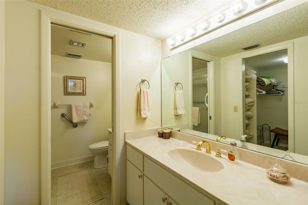 8767 Midnight Pass Road, Unit 506F Sarasota, FL 34242 - Photo 23 of 37 a bathroom with a granite countertop sink mirror and a toilet