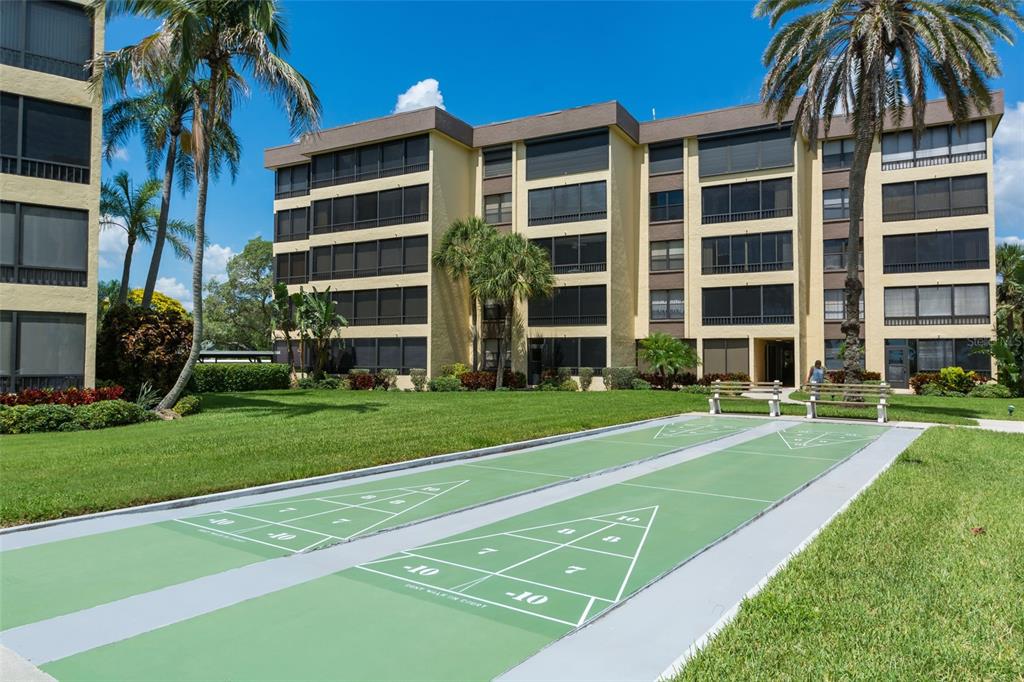 8767 Midnight Pass Road, Unit 506F Sarasota, FL 34242 - Photo 30 of 37 a front view of a building and a yard