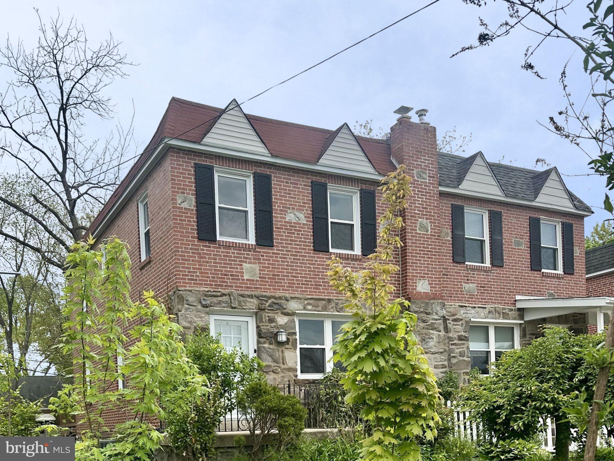 Charming brick home with lush greenery.