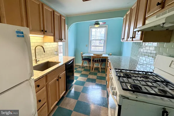 a kitchen with granite countertop a stove a sink and a microwave