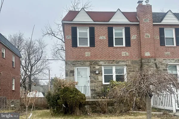 a view of a brick house with many windows and plants