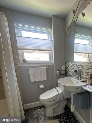 a bathroom with a sink toilet and a window