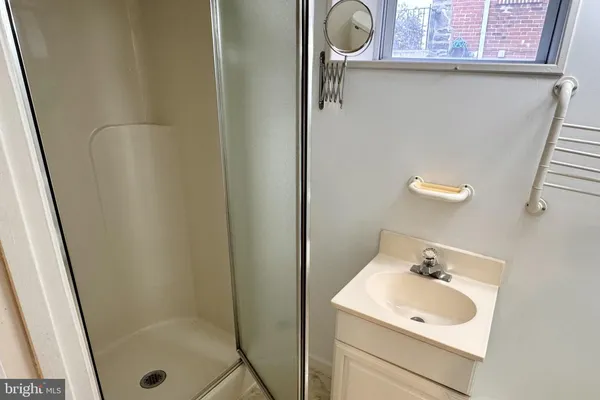 a bathroom with a sink a mirror and shower