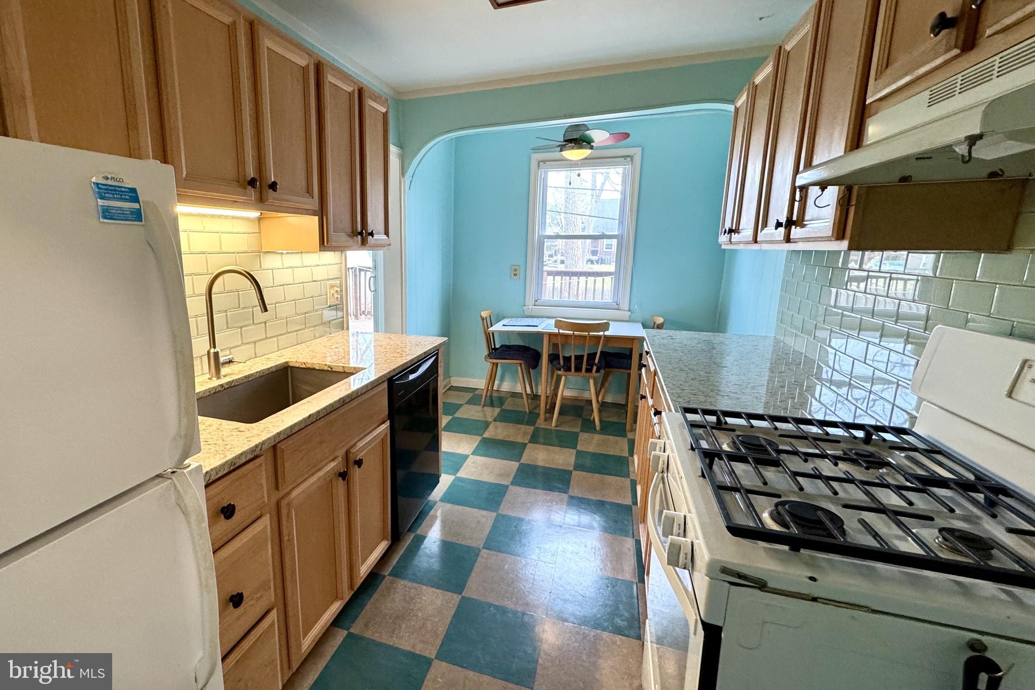 61 Greenhill Road Media, PA 19063 - Photo 10 of 37 a kitchen with granite countertop a stove a sink and a microwave