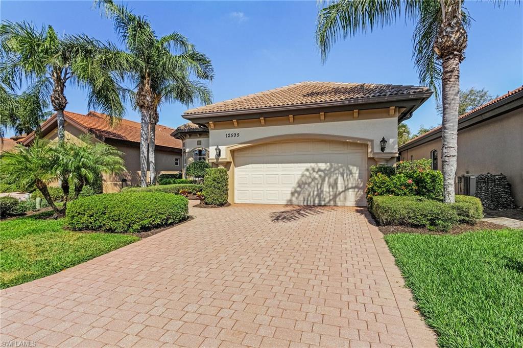 12595 Grandezza Circle Estero, FL 33928 - Photo 24 of 33 a front view of a house with a garden