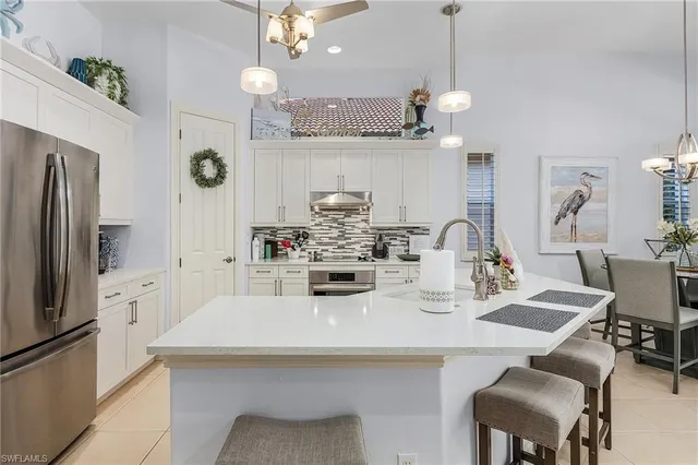a kitchen with refrigerator and chairs