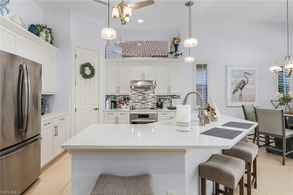 12595 Grandezza Circle Estero, FL 33928 - Photo 3 of 33 a kitchen with refrigerator and chairs