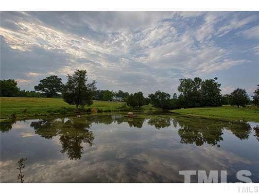 9123 South Lowell Road Bahama, NC 27503 - Photo 23 of 25 a view of a lake with a yard and large trees