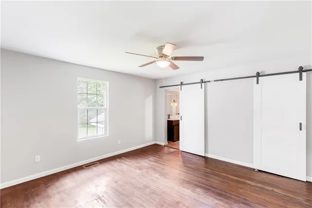 a view of a big room with wooden floor and a ceiling fan