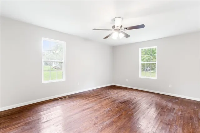a view of an empty room with wooden floor